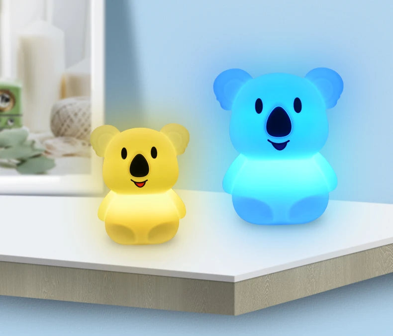 A yellow koala LED night light and a blue koala LED night light sitting on a white surface.