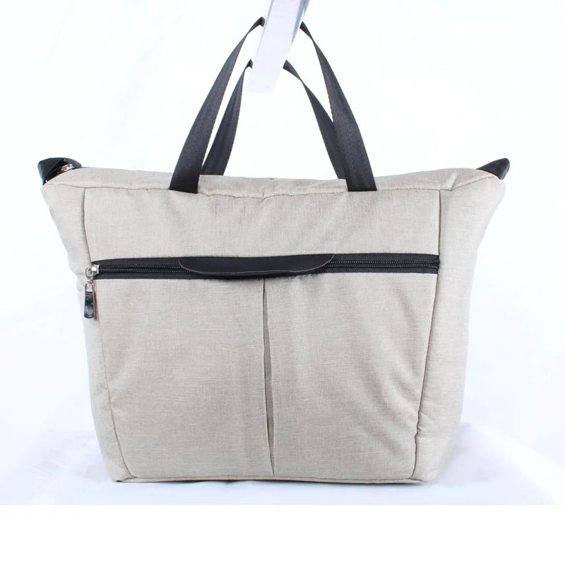 A beige fabric bag with black straps and a zippered pocket is shown against a white background.