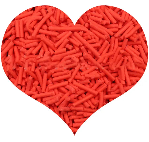 A heart shape filled with bright orange cylindrical polymer clay candy sprinkles for cake decorating