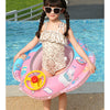 A young girl is sitting in a pink inflatable aircraft swim ring with a yellow steering wheel in blue water.