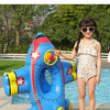 A young girl is standing next to a blue inflatable aircraft swim ring for kids outdoors.