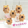 A display of several fluffy brown capybara plush toys hanging in a white wire grid.