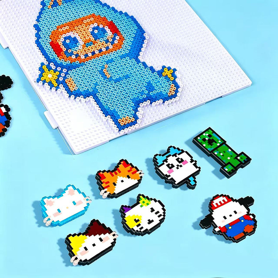 A Perler bead craft kit showing a blue and orange monster design on a white grid, with several finished animal figures scatte