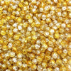 Close-up view of small, round, yellow glass crackle beads for jewelry making