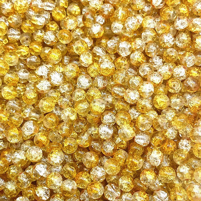 Close-up view of small, round, yellow glass crackle beads for jewelry making