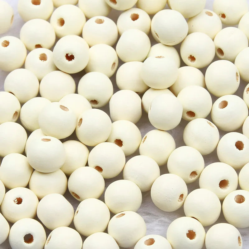 A close-up view of small, natural wooden beads in various off-white and cream colors.