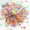 A pile of colorful polymer clay sprinkles in various shapes and colors for slime and craft decoration