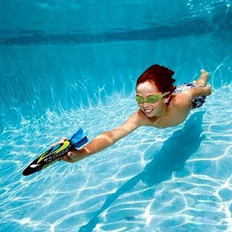 A person swimming underwater with a blue diving torpedo toy.
