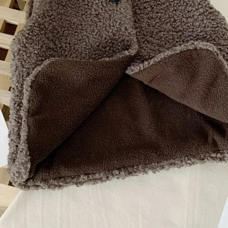 A close-up of a brown and gray faux lamb wool vest for children, showing the texture and layered design.
