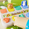 A Montessori pop-up animal toy featuring a yellow farm scene with animals and a blue hide-and-seek figure.