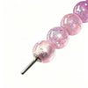 A series of pink glitter balls attached to a metal pen tip for diamond painting.