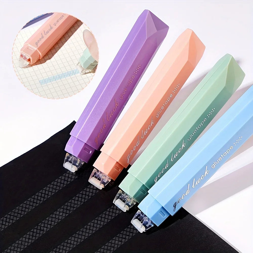 A set of four colored glue rollers in purple, peach, light green, and blue are displayed on a black surface.