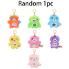 Random plush keychain charms in various colors including orange green blue yellow pink and purple