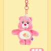 A pink Care Bears plush toy with a heart design attached to a silver keychain ring.