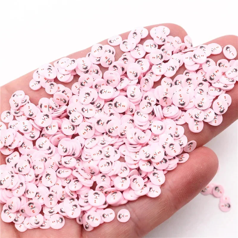 A hand holds a large pile of pink polymer clay slices for DIY crafts.