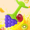 A bright green silicone fruit-shaped baby teether is shown surrounded by various fresh fruits like an apple, strawberry, and 