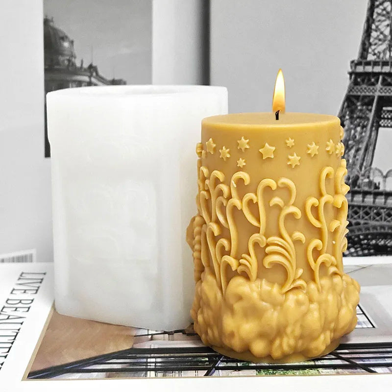 A golden silicone mold shaped like an angel is shown next to a white pillar candle.