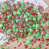 A scatter of mixed resin rhinestone pearls in various shades including green, pink, and gold on a white background.