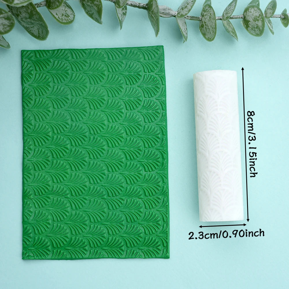 A green floral texture roller is shown next to a roll of white material on a light blue background.