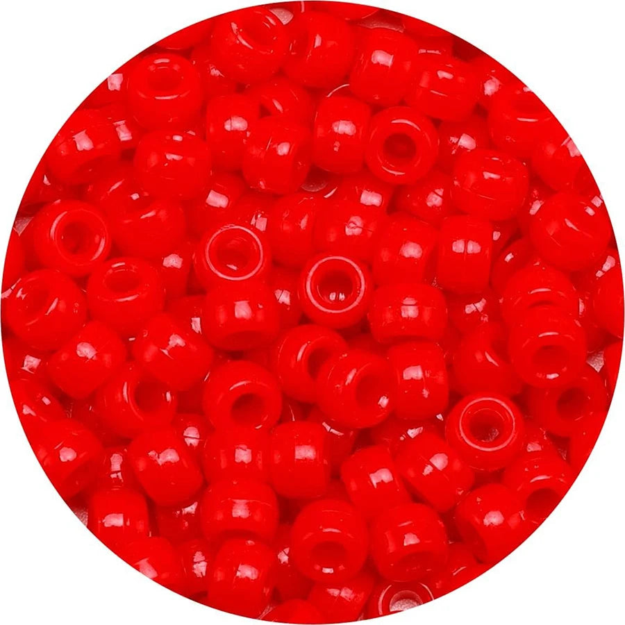A close-up view of small, round red pony beads for jewelry making.
