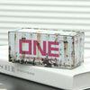 A rectangular metal storage box with a distressed, rusted finish and a pink label on a white background.