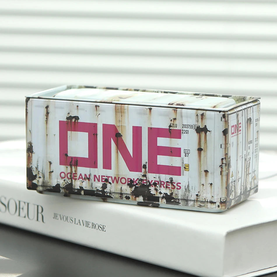 A rectangular metal storage box with a distressed, rusted finish and a pink label on a white background.