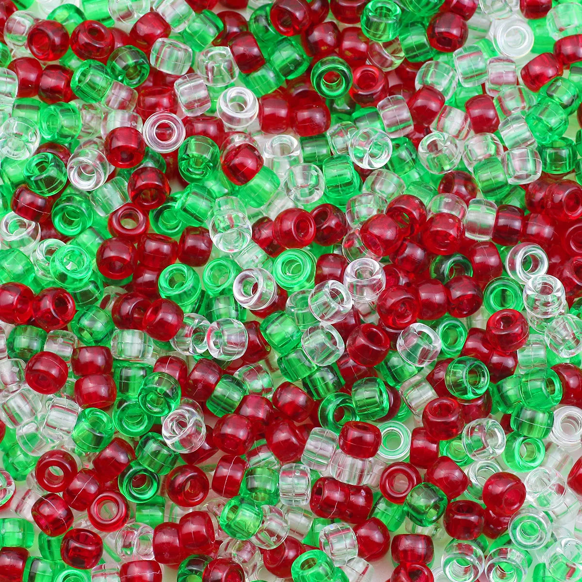 A close-up view of small, solid color pony beads in red, green, and clear plastic.