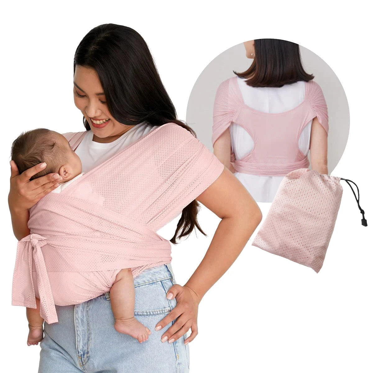 A woman is using an X-shaped baby sling carrier in pink to hold a baby, with a matching pink fabric bag nearby.