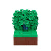 A LEGO building block model depicting Homer in the bushes scene with green foliage and a brown base.