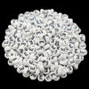 A pile of small white acrylic alphabet letter beads for jewelry making