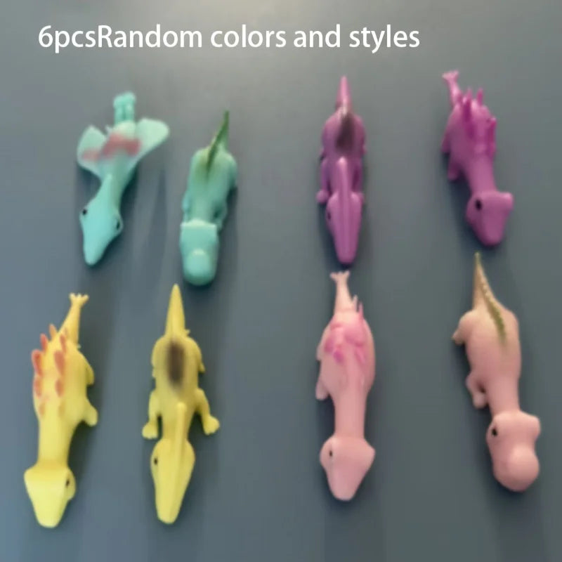 A collection of six mini dinosaur finger slingshots in various random colors and styles.