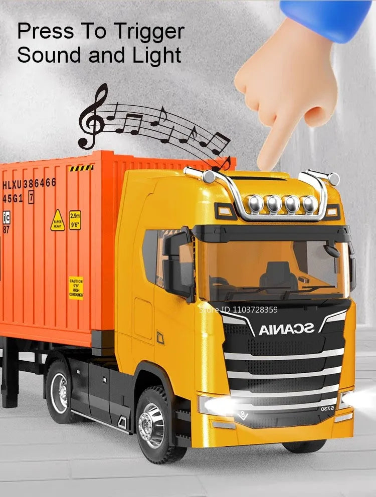 A yellow diecast container truck model is shown with a hand pressing a trigger to activate sound and light features.