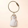A clear, dog-shaped pet hair keepsake keychain with a white cat figure attached to a braided cord.