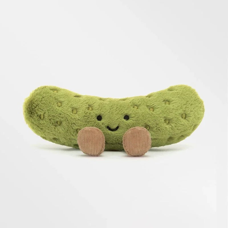 A soft, green plush pickle toy with brown features, designed as a quirky desk decor.