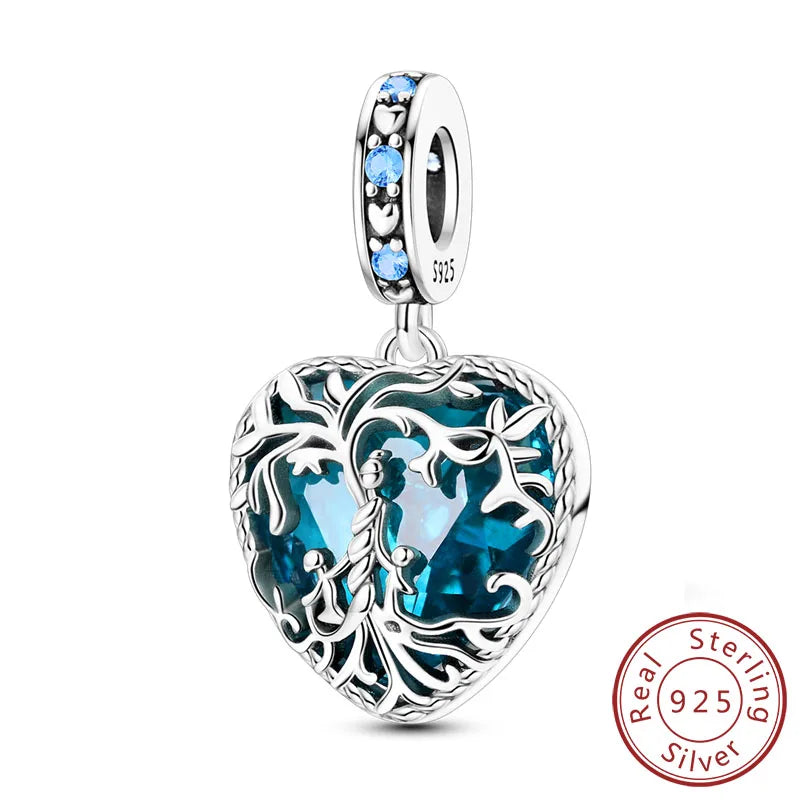 A sterling silver heart charm bead featuring blue stones and intricate foliage design.