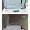 A light blue stroller organizer bag with a gray cupholder and a pink baby bottle shown against a soft green background.