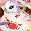 A child is using an interactive dinosaur drawing robot to draw a squid on paper.
