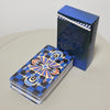 A blue Rider-Waite Tarot deck box and a stack of cards lying on a light surface.