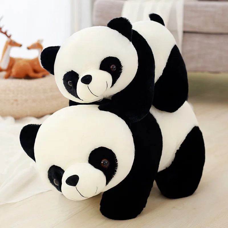 A pair of adorable soft panda plush pillows, one larger than the other, resting on a light surface.