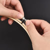 Hands are adjusting adjustable bamboo embroidery hoops for needlecraft.