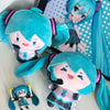 A plush keychain of an anime girl with bright blue hair and a pink outfit.