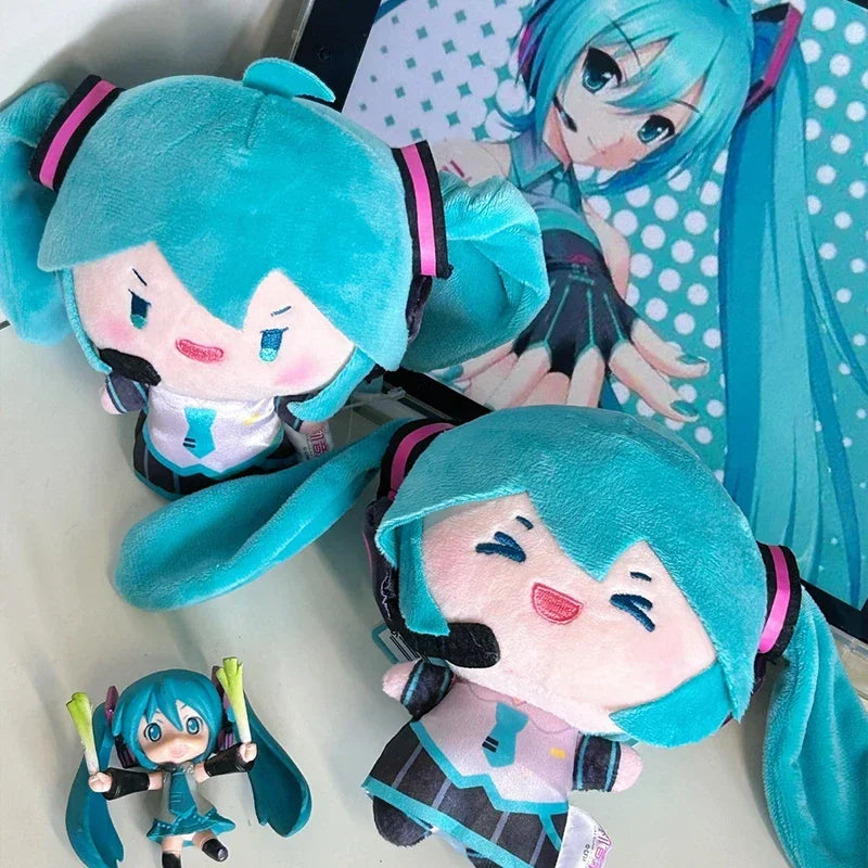 A plush keychain of an anime girl with bright blue hair and a pink outfit.