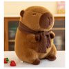 A brown plush capybara stuffed animal wearing a knitted brown scarf sitting on a white surface.