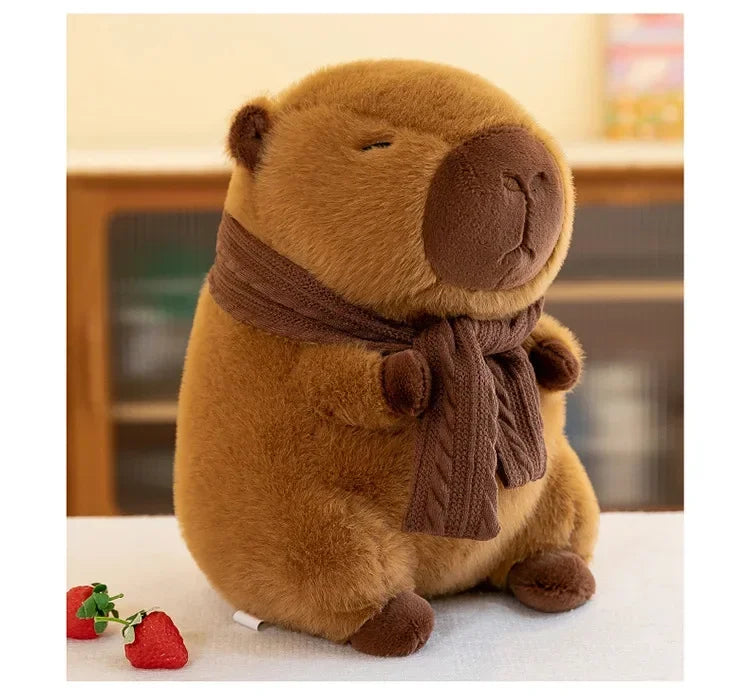 A brown plush capybara stuffed animal wearing a knitted brown scarf sitting on a white surface.