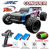 A black and purple 1:14 scale RC monster truck with large tires and a brushless motor, along with a remote control transmitte