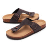 A pair of brown suede cork mules with a leather strap and arch support.