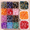 A collection of gradient crystal glass beads with a golden crackle finish in various colors displayed in a clear plastic tray