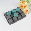 A silicone soap mold tray with twelve square cavities, featuring teal and gray silicone molds.