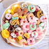 A bowl filled with assorted colorful donut-shaped resin candies for DIY crafts and jewelry making