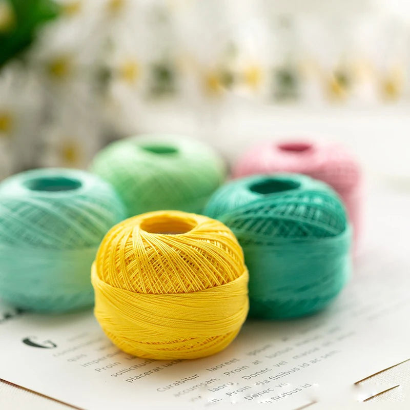 A ball of bright yellow crochet thread resting on a white surface with blurred background elements.